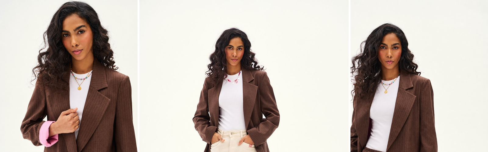 Woman in a brown pinstripe blazer with a white T-shirt and cream trousers, studio photograph