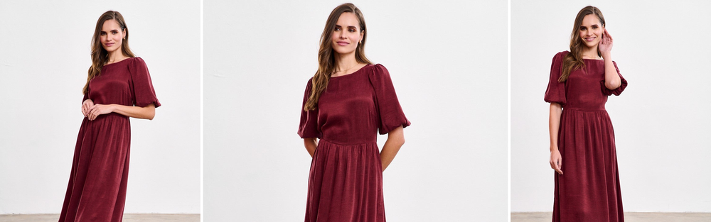 Woman in a burgundy satin midi dress, a dark red with a violet undertone.