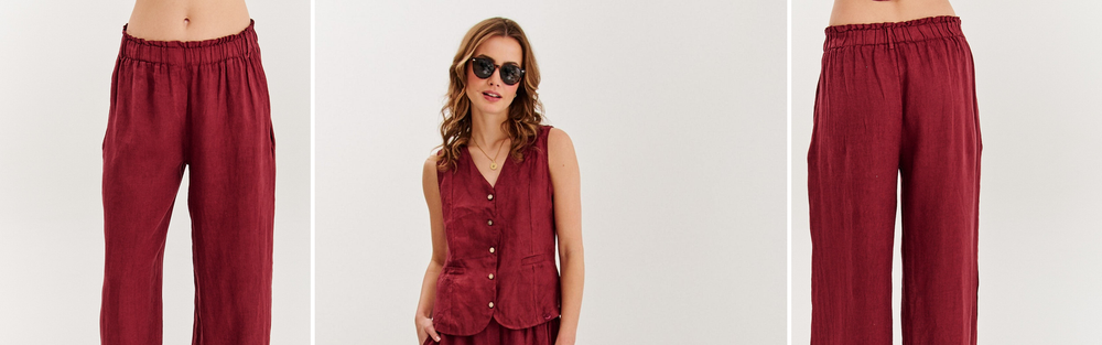 Woman in burgundy wide leg linen trousers, studio photograph