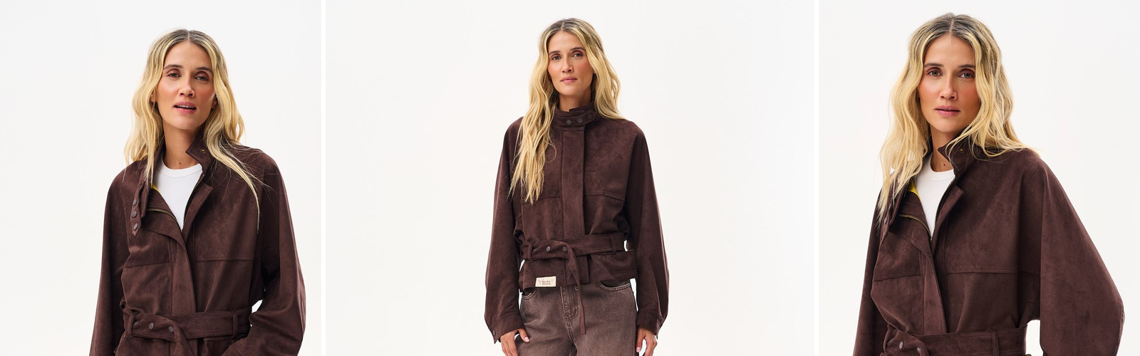 Woman in a short chocolate brown suede jacket belted at the waist, worn with a white top and brown jeans, studio photograph