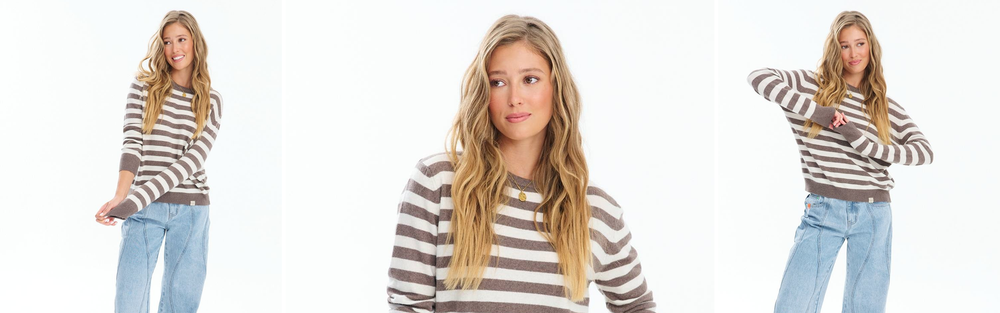 Woman in a striped cashmere blend sweater and jeans, studio photograph