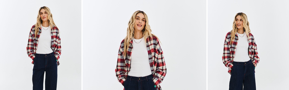 Woman in dark wide leg jeans and a checked shirt, studio photograph