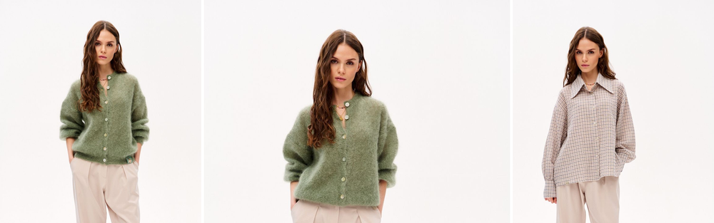 Woman in light sand trousers and a green knit cardigan, studio photograph